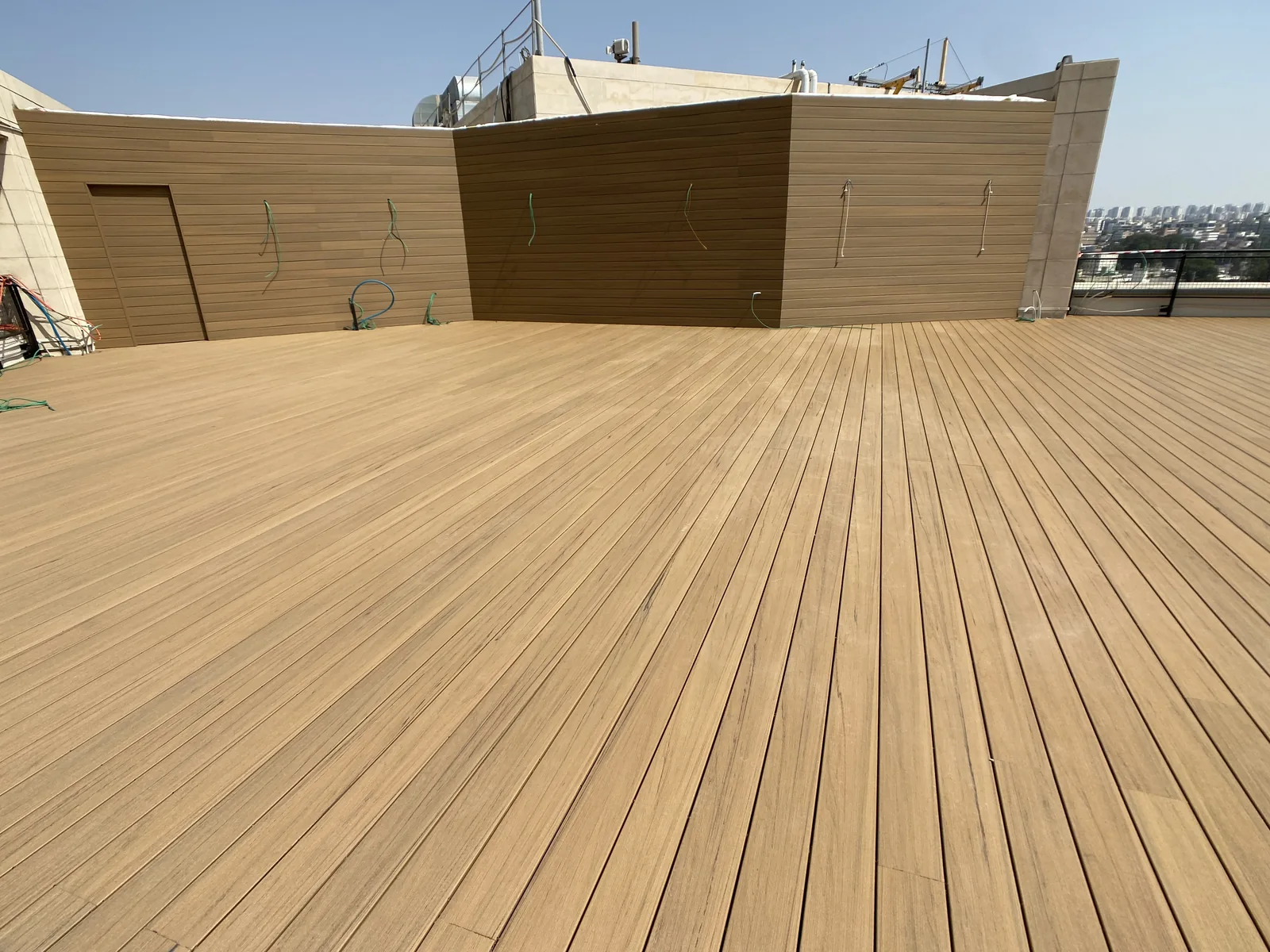 דק וחיפוי קיר תואמים בגוון קוקוס ממשפחת TimberTech במהלך עבודה