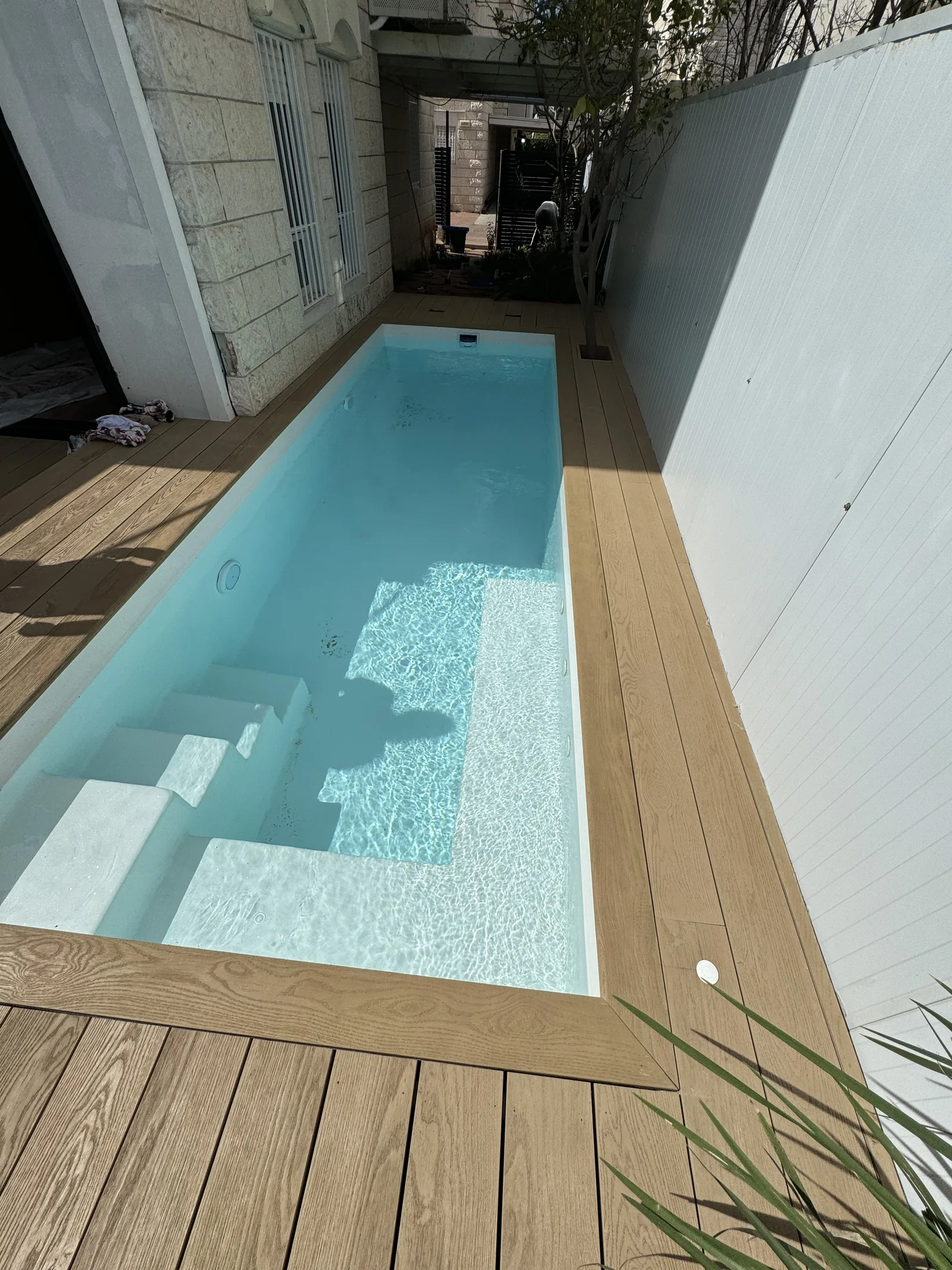 דק Millboard Golden Oak סביב בריכה צרה וארוכה בחצר