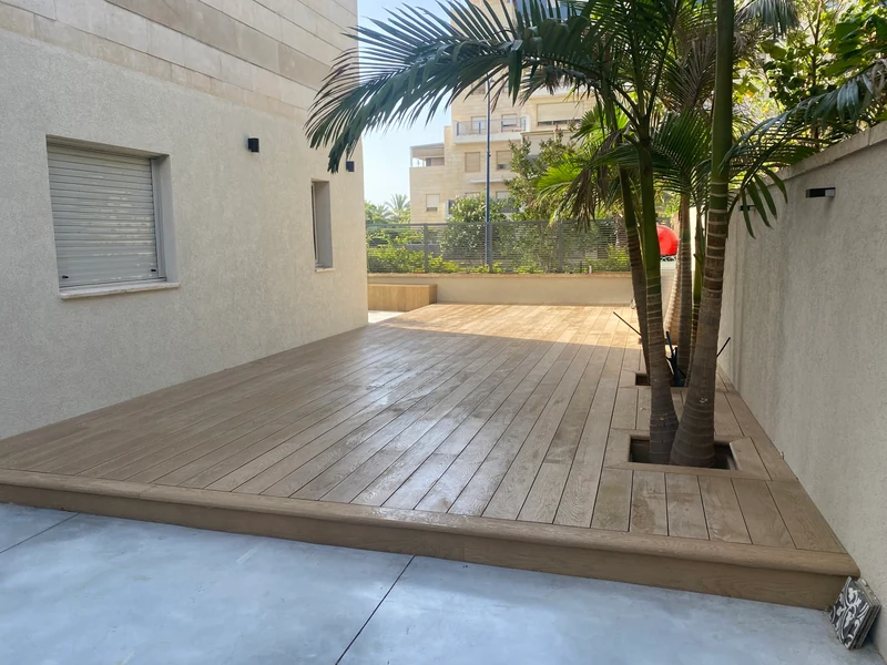 דק וחיפוי Millboard בחצר עם עצי דקל ברחובות